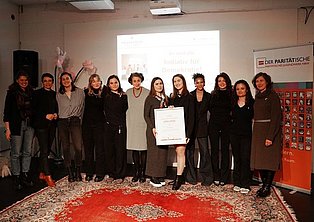 Mehrere junge Menschen posieren mit einer Urkunde für die Kamera