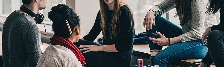 Fachkräfte sitzen im Kreis und diskutieren