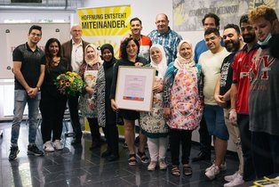 Die Projektgruppe, die den Preis gewonnen hat, mit Urkunde und Scheck