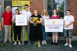 Vertreter*innen des Preisträgers mit Urkunden und Scheck