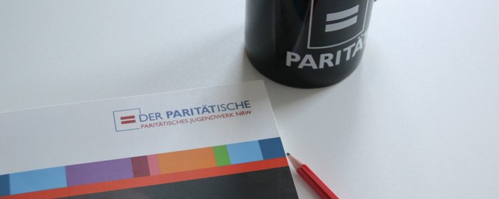 Eine PJW-Broschüre, Kaffeetasse und Bleistift