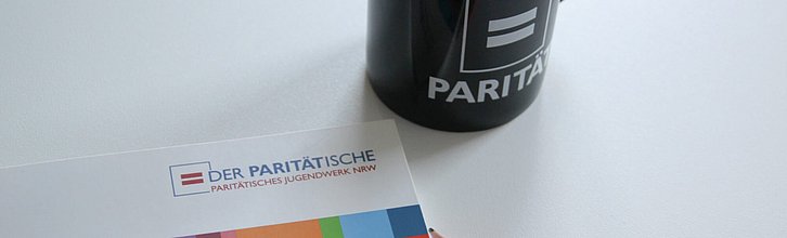 Eine PJW-Broschüre, Kaffeetasse und Bleistift